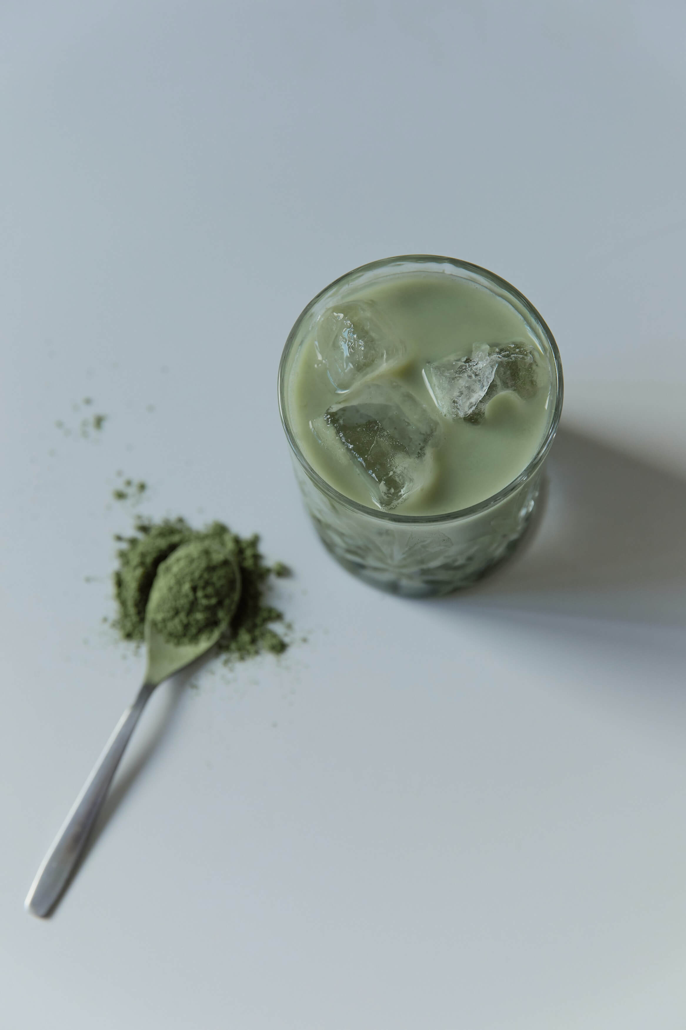 Hier sieht man ein hochwertiges Glas aus einer unserer Kollektionen. In dem Glas ist Matcha Latte mit Eiswürfeln enthalten. Das Glas ist stilvoll und funktional.