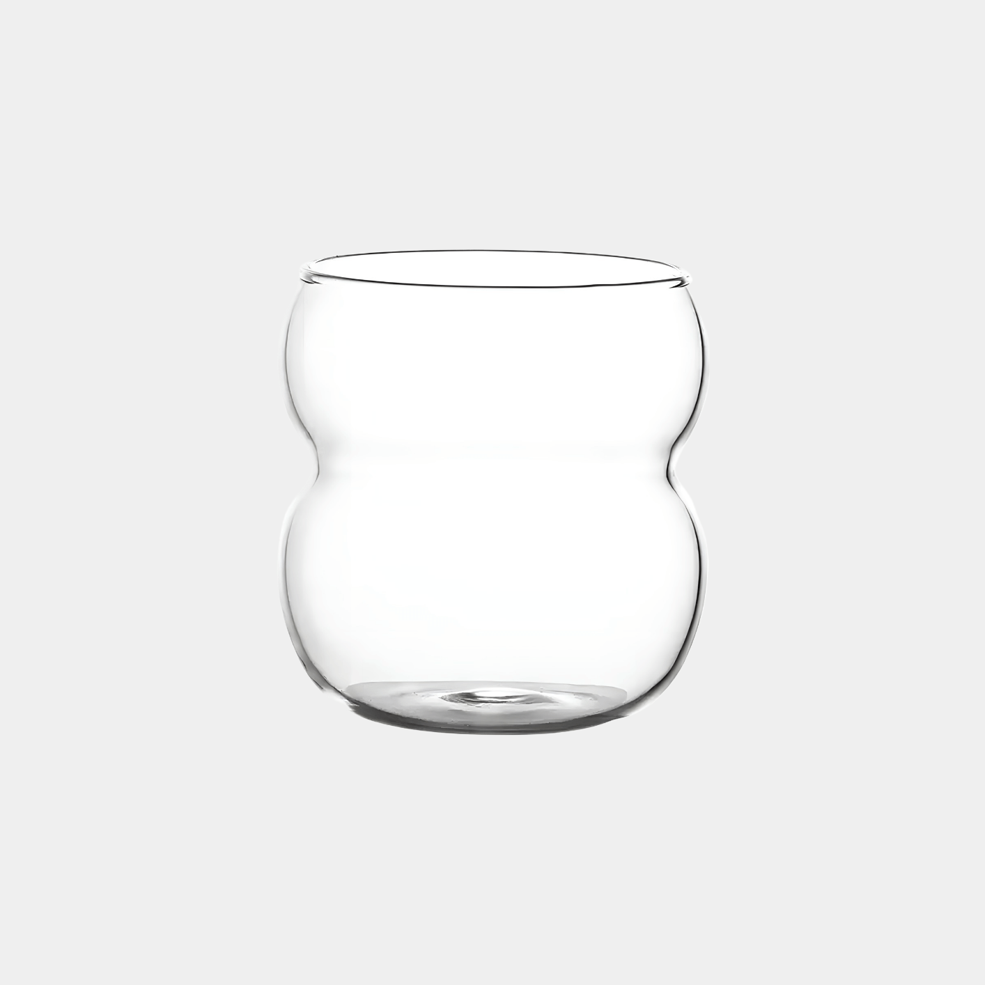 Ein stilvolles, modernes Bubble Glas | Parisian Love, präsentiert vor einem grauen Hintergrund - Luxuriöses Trinkglas mit zeitlosem, gewölbtem und welligem Design sowie ästhetischem Appeal. Handgefertigt und mundgeblasen für ein einzigartiges Trinkerlebnis. Perfekt für Cocktails, Kaffee oder Erfrischungsgetränke. Ein Blickfang auf jedem Tisch. Ideal für den täglichen Gebrauch oder besondere Anlässe. Erleben Sie Luxus und Eleganz mit diesem hochwertigen, einzigartigen und edlen Trinkglas.
